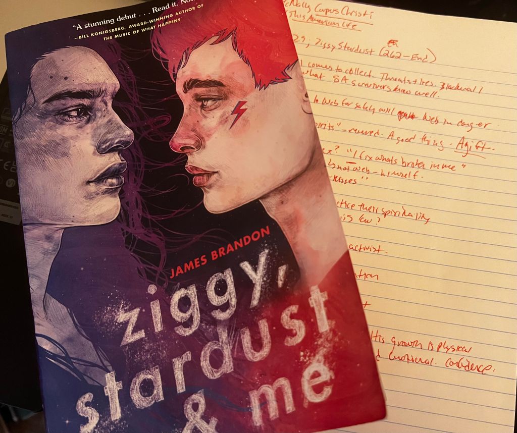 Paperback copy of Ziggy, Stardust & Me sitting partially atop lined notebook page with notes written in red ink. 